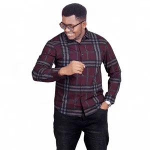A man wearing a burgundy casual slim fit check shirt with long sleeves, button-down front, styled with black jeans for a smart-casual look