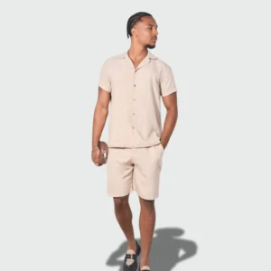 Man wearing a beige linen shirt and shorts, styled for summer resort and casual wear