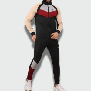 Man wearing a men’s slim fit tracksuit with zip-up jacket and tapered jogger pants featuring a sporty color-block design