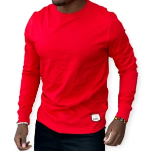 Man wearing a long sleeved red cotton t-shirt with a slim fit, styled casually with black jeans for everyday wear