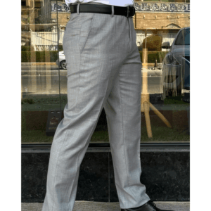 Man wearing silver grey formal pants paired with black leather dress shoes, photographed in a smart outdoor setting.