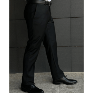 Man wearing black wool formal pants paired with black leather dress shoes, photographed in a modern indoor setting.