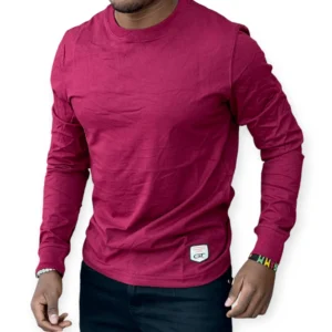 man wearing a burgundy slim fit cotton tee with a classic crew neck design, styled casually with dark jeans for everyday wear