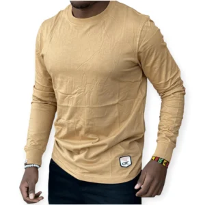 man wearing a beige long sleeved men's cotton t-shirt with a classic crew neck design, styled casually with dark jeans for everyday wear