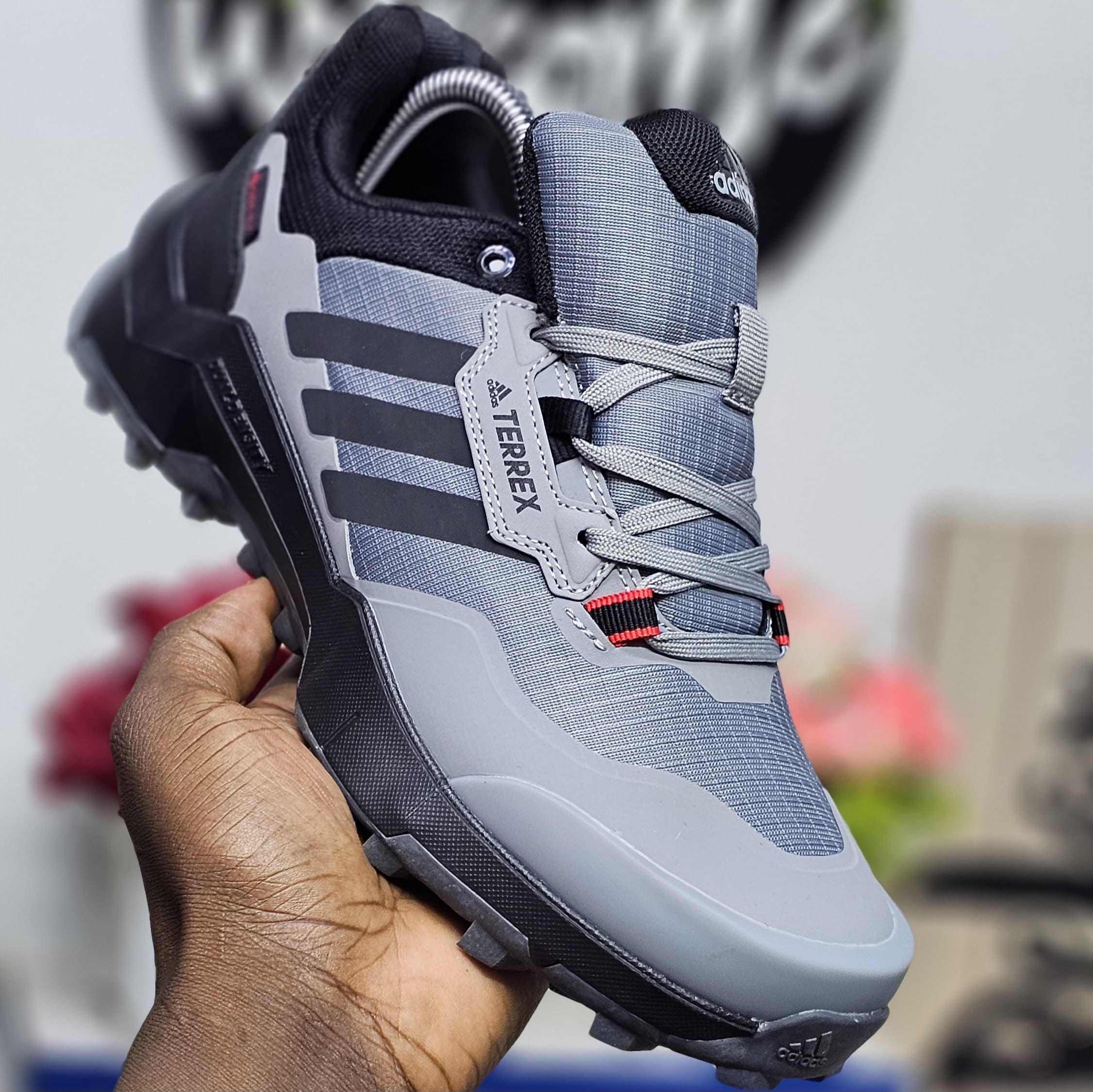 Grey Adidas Terrex sneakers with rugged sole and lace-up design, suitable for outdoor wear, hiking, and everyday street style.