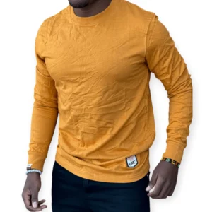 Man wearing a mustard yellow cotton t-shirt with a slim fit, styled casually with dark jeans for everyday wear