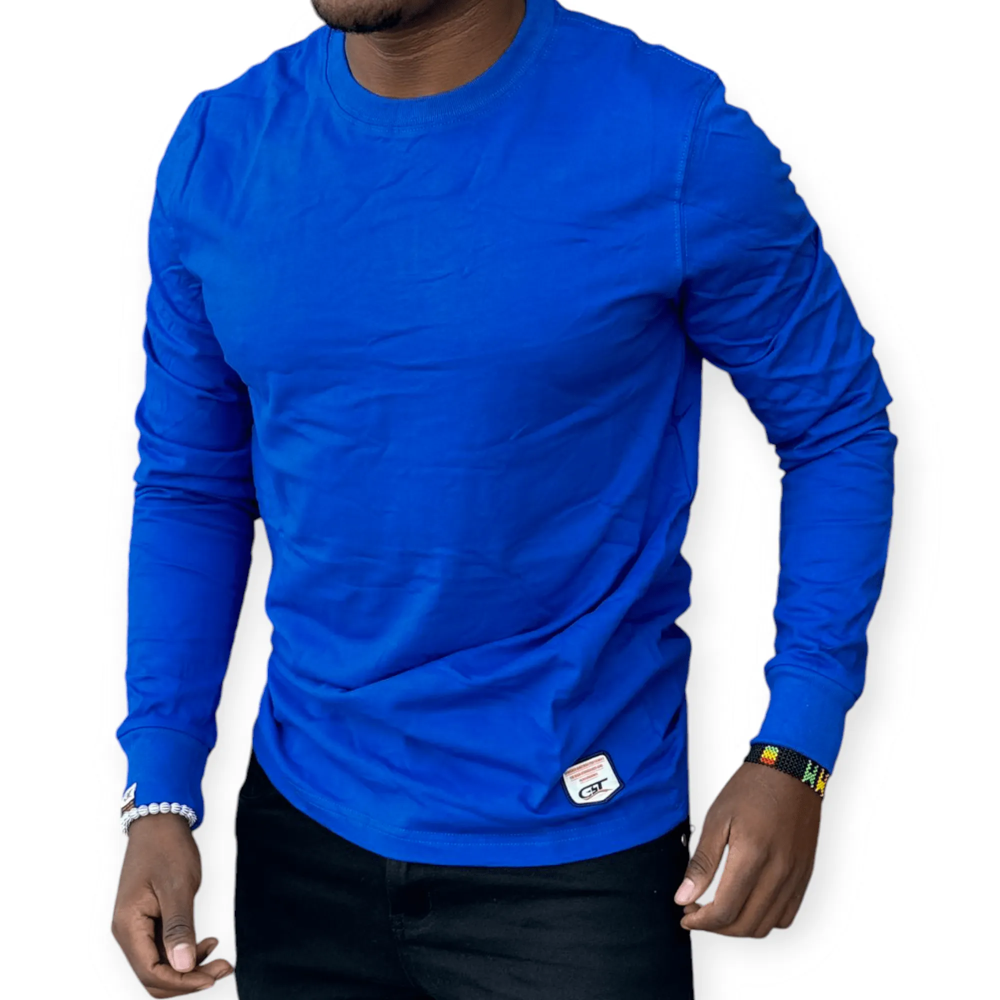 Man wearing a royal blue long sleeve cotton tee with a round neck, styled casually with dark jeans for everyday wear