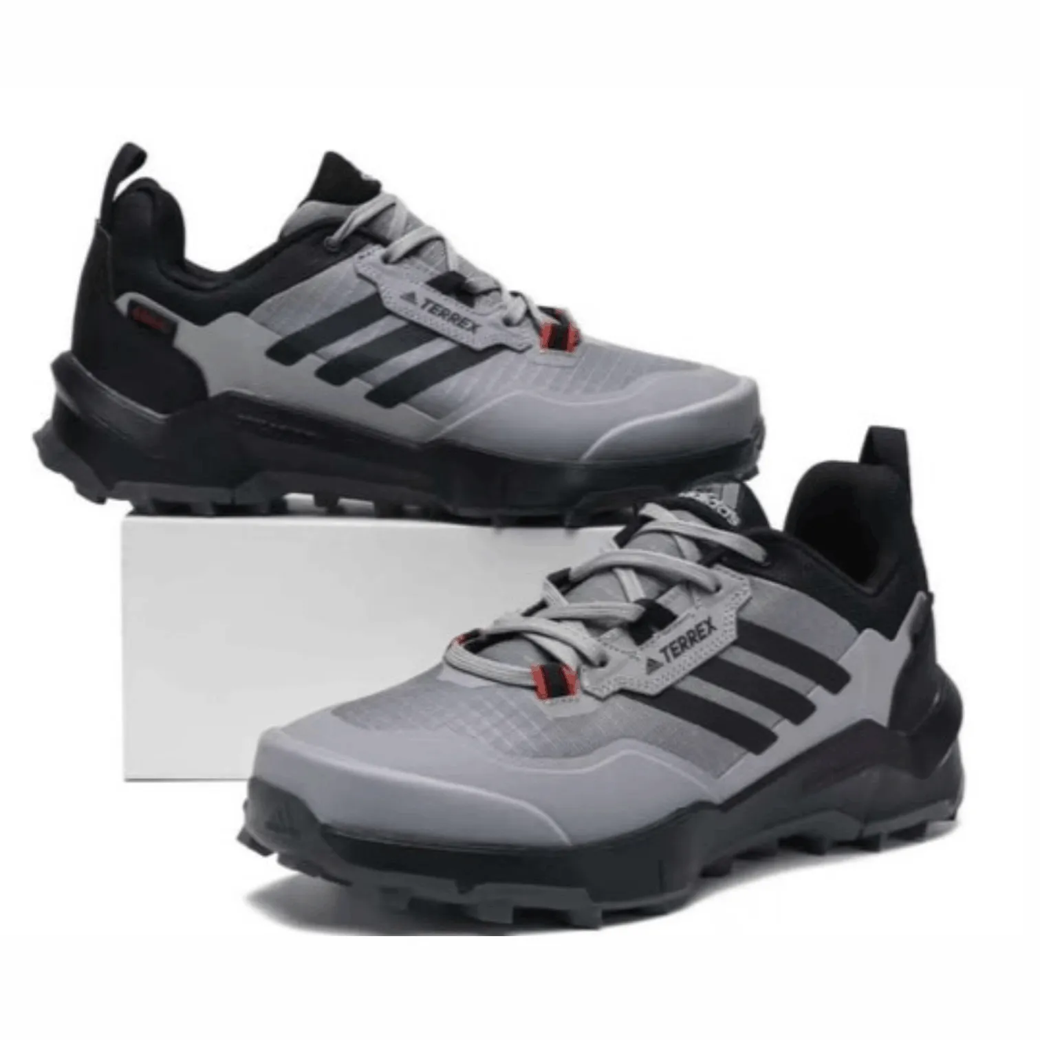 Grey Adidas Terrex sneakers with rugged sole and lace-up design, suitable for outdoor wear, hiking, and everyday street style.
